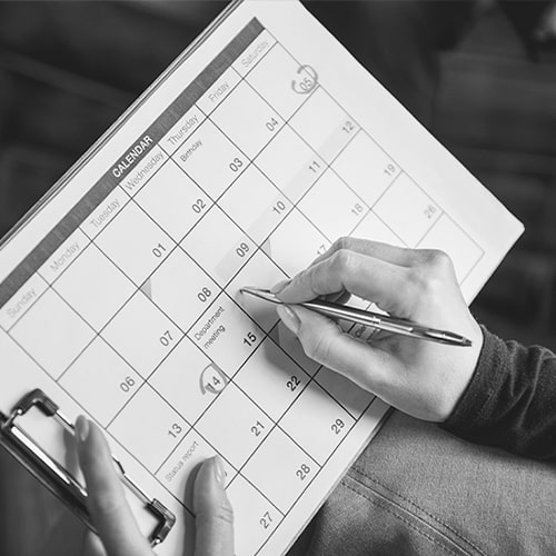 A person using a calendar to create a schedule